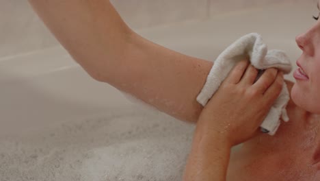 Beautiful-woman-in-bath-scrubbing-soap-of-her-arm