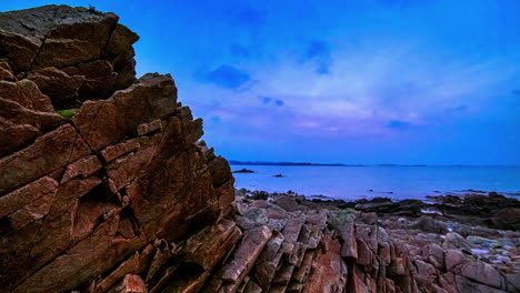 Rock-Formation-And-Rocky-Shoreline-Of-Beach-From-Dusk-To-Night-In-Guernsey