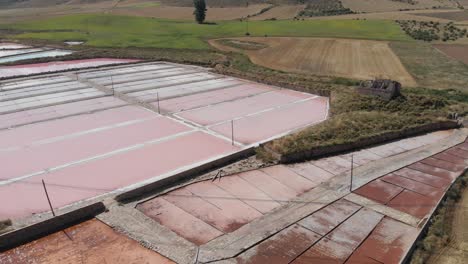 Aerial-panning-over-the-Salinas-de-Imon-facilities,-with-intense-colors-in-the-drying-pools