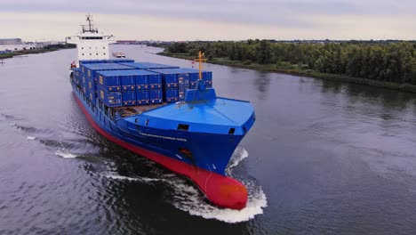 Orbit-Shot-Of-Huge-Blue-Tailwind-Panda-Container-Ship-Sailing-In-Oude-Maas-River,-Netherlands