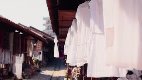 White-linen-dress-hanging-in-the-wind-in-an-old-market-place