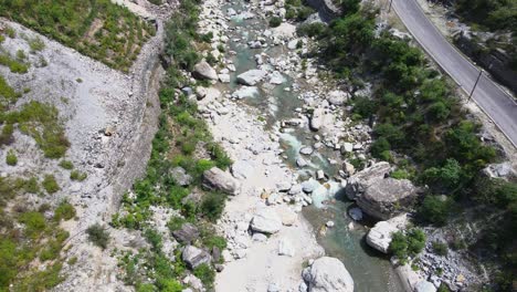Drone-Shot-of-a-small-road-and-river-in-Himachal-Pradesh-near-Manali,-Kasol-2