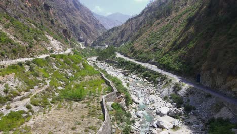 Drone-Shot-of-a-small-road-and-river-in-Himachal-Pradesh-near-Manali,-Kasol-4