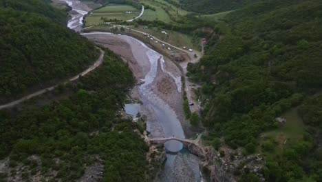 Drone-looking-down-at-the-valley-with-Benja-thermal-baths-and-Vjosa-river-in-Albania