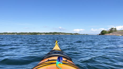 Yellow-open-water-kayak-floating-on-water-with-sunny-view-of-archipelago-in-the-background