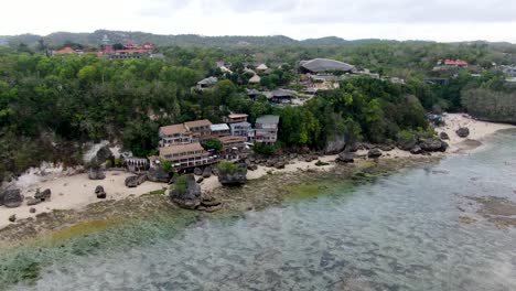 Luxury-coastal-lodge-on-sandy-beach-in-Padang-Padang-in-Bali,-aerial-view