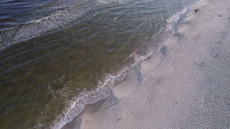 Aerial-drone-flies-over-beach,-sandbar-as-waves-crash-on-the-beach