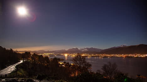 The-moon-and-stars-cross-the-sky-above-the-sea-port-of-Alesund,-Norway---nighttime-time-lapse