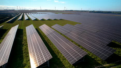 Aerial-Trucking-Shot-Of-Photovoltaic-Farm-With-Eco-Friendly-Wind-Turbine-Farm-Im-Hintergrund-Im-Sommer---Futuristisches-Konzept-Von-Windenergie-Und-Sonnenlicht