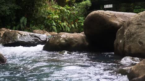 El-Agua-Que-Fluye-Rápidamente-Surge-Entre-Grandes-Rocas-En-El-Río-Celeste
