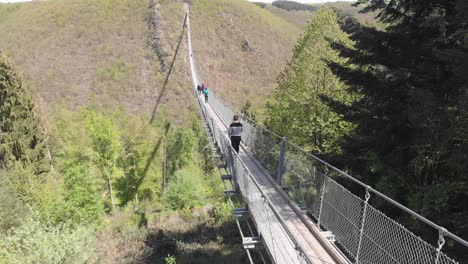 Persona-Cruzando-El-Puente-Colgante-Geierlay-En-El-Valle-Del-Mosela,-Alemania