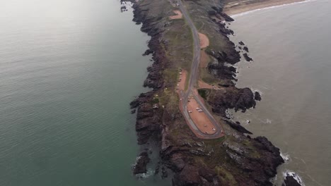 Aerial-top-down-shots-of-parking-tourist-cars-at-Punta-Ballena-Lookout-Point-during-cloudy-day-in-Uruguay