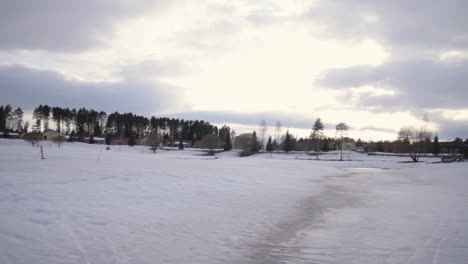 A-panorama-of-a-snowy-scene-low-to-the-ground,-looking-around-in-Vuokatti-Finland,-panning-left