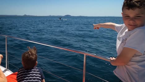 Excited-child-points-to-whale-fin-as-it-dives-into-the-ocean