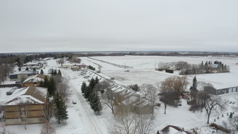 Aerial-view-flying-over-a-small,-snow-covered-Canadian-community-in-the-prairies