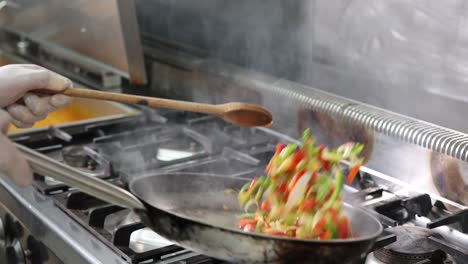 Chef-cooking-and-flambéing-vegetables-in-a-frying-pan,-4K-footage
