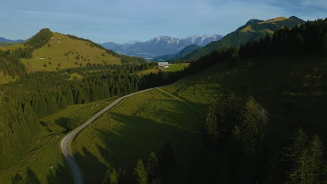 Green-grass-meadows-in-the-romantic-and-scenic-Bavarian-Austrian-Sudelfeld-Wendelstein-alps-mountain-peaks-with-panorama-view-road