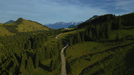 Car-in-the-Bavarian-Austrian-Sudelfeld-Wendelstein-alps-mountain-peaks-with-romantic-green-grass-meadows-and-panorama-view-road