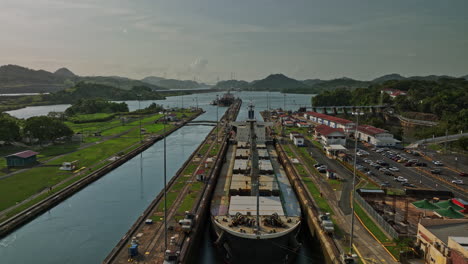 Panama-City-Aerial-v34-low-level-flyover-industrial-attraction,-narrow-miraflores-locks-towards-canal-lake-with-two-cargo-tanker-ships-transiting-at-the-waterway---Shot-with-Mavic-3-Cine---March-2022