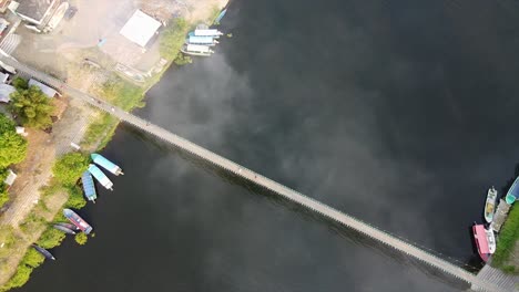 Aerial-view-of-a-wooden-bridge-in-La-Antigua,-Veracruz,-Mexico-over-the-clouds-and-a-river-located-near-a-fishing-village