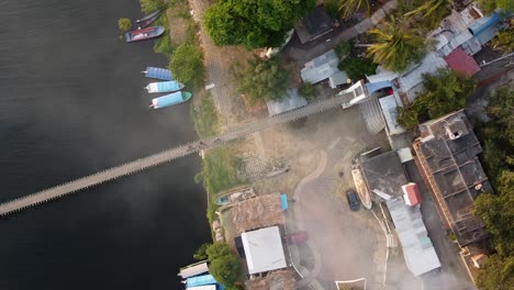 Spiraling-down-a-fishing-village-in-La-Antigua,-Veracruz,-Mexico-with-a-wooden-bridge-over-a-river