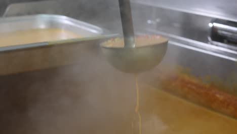 Chef-mixing-curry-sauce,-close-up-on-a-hand,-4k-footage