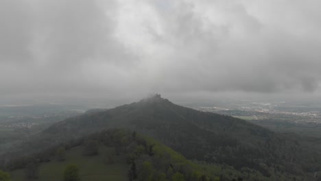 Slow-aerial-dolly-shot-towards-Hohenzollern-Castle-from-Zeller-Horn-mountain,-shrouded-in-cloud