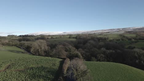 Rolling-green-Lancaster-hills-dusted-with-snow-on-autumn-day,-aerial