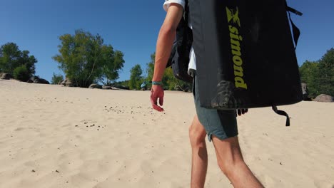 Young-teenage-boy-with-crashpad-on-his-back-walks-through-sand-dunes-fontainebleau-cul-de-chien
