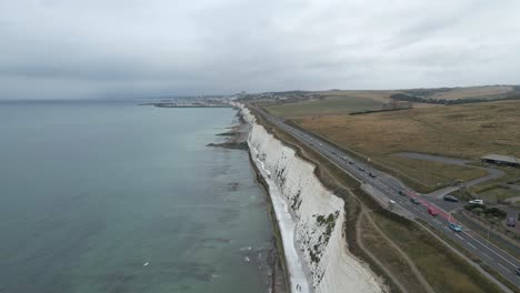 Aerial-flight-along-tall,-steep-white-chalk-cliffs-of-English-seashore