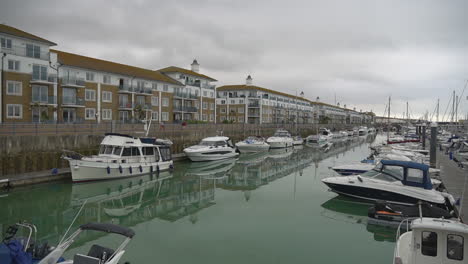 Boats-of-all-sizes-line-quiet-ocean-marina-docks-on-grey-overcast-day