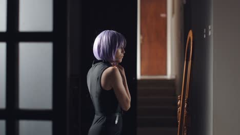 Young-woman-approaching-the-mirror-to-check-and-fix-her-purple-hair
