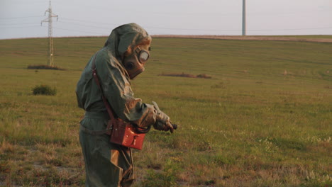 Person-wearing-a-protective-suit-and-gas-mask-measures-and-collects-data-on-the-contaminated-area