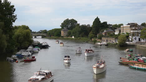 Flotilla-of-boats-drift-on-River-Thames-in-Riverside-Green,-Richmond