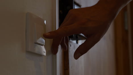 Hand-switches-lights-off-in-room-to-save-money-on-home-electricity-usage