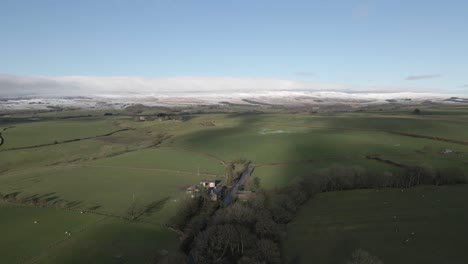Autumn-aerial:-Lush-green-Lancaster-pastures-with-snow-on-distant-hill