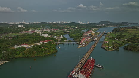 Panama-City-Aerial-v32-establishing-drone-flyover-miraflores-lake-with-cargo-ship-transiting-at-canal-locks-with-downtown-cityscape-in-the-background---Shot-with-Mavic-3-Cine---March-2022