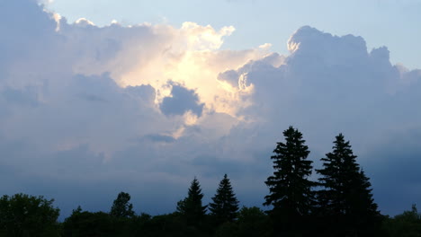 Warme-Sonne-Versteckt-Sich-Hinter-Dunkelgrauen-Wolken-über-Waldbäumen-In-Der-Silhouette
