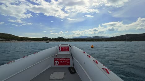 First-person-view-of-bow-of-tour-boat-sailing-toward-famous-pristine-Saleccia-beach-in-Corsica,-France