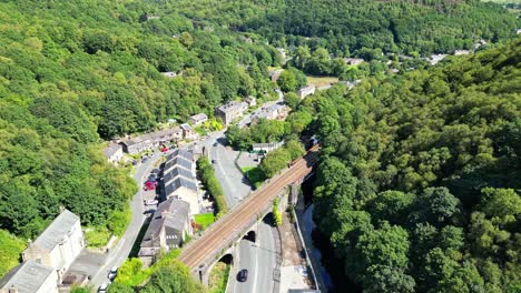 Aerial-drone-footage-of-a-West-Yorkshire-Village-with-Canal,-River-and-woodland-surroundings