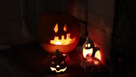 Candle-is-lightning-inside-of-Halloween-pumpkin,-decorations-at-night