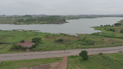 AERIAL---Lamingo-Dam-and-highway,-Jos-Plateau,-Nigeria,-forward-shot