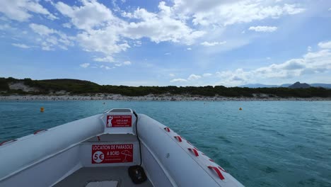 First-person-view-of-bow-of-touristic-boat-sailing-toward-famous-Saleccia-beach-in-Corsica,-France