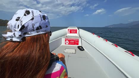 First-person-view-of-redhead-child-on-speed-boat-sailing-over-north-Corsica-sea-water-for-tour