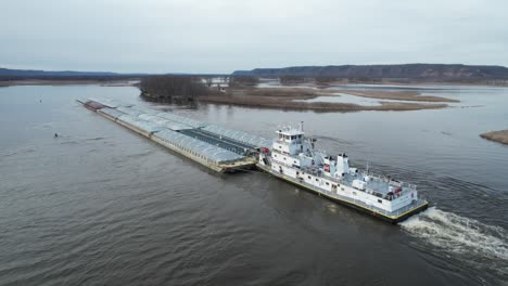 Approaching-Lansing,-Iowa,-a-towboat-pushing-barges-north-on-the-Mississippi-River-7