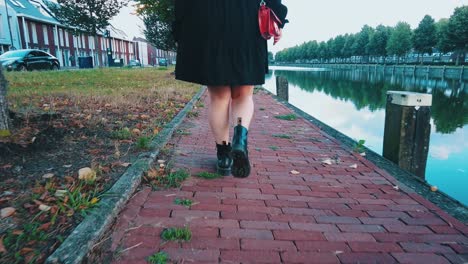 Sexy-women-legs-in-dress-and-boots-walk-on-quay-riverside-slomo-the-netherlands