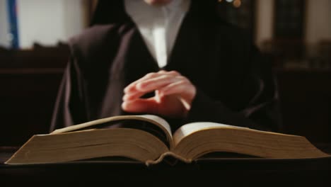 Nun-is-reading-and-flipping-pages-of-the-bible,-spiritual-concept