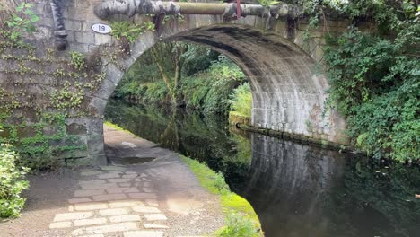 Old-stone-bridge-over-a-English-canal-showing-towpath-and-old-pipework