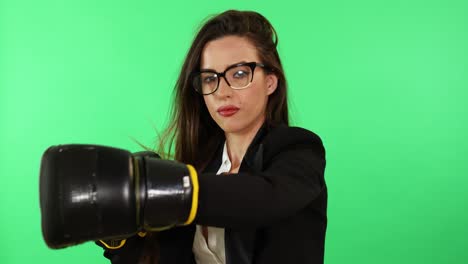 Sexy-brunette-young-woman-with-glasses-white-shirt-and-black-business-suit-wearing-boxing-gloves-and-punching-stress