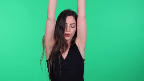 Young-brunette-woman-wearing-boxing-hand-wraps-punching-toward-camera-with-green-screen-in-background